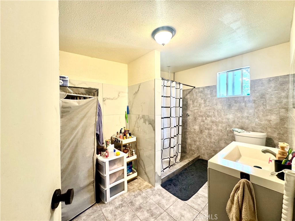 1042 North Alice Avenue Rialto, CA 92376 - Photo 30 of 31 a bathroom with a sink and a shower