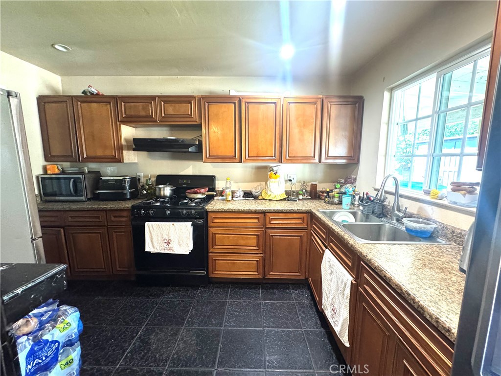 1042 North Alice Avenue Rialto, CA 92376 - Photo 9 of 31 a kitchen with a sink stove and cabinets