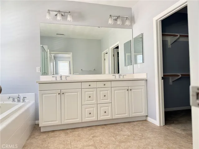 a bathroom with a granite countertop sink vanity and mirror