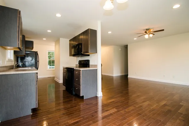 a view of kitchen with cabinets stainless steel appliances and wooden floor