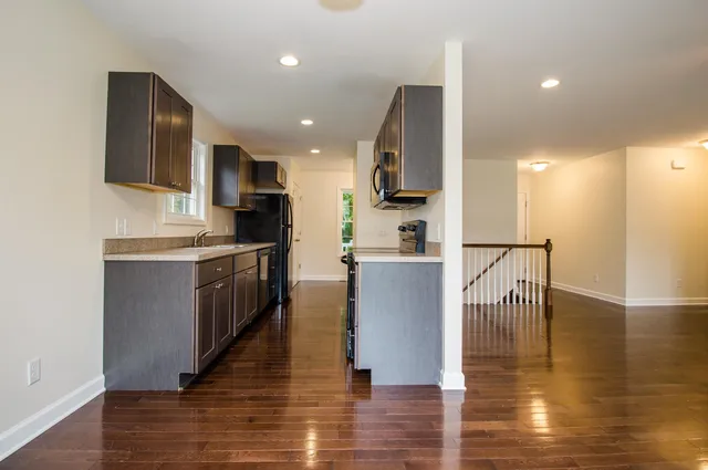 a open kitchen with stainless steel appliances granite countertop a stove top oven a sink and a refrigerator