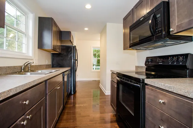 a kitchen with stainless steel appliances granite countertop a sink stove and microwave