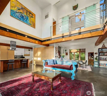 a living room with furniture a rug and kitchen view