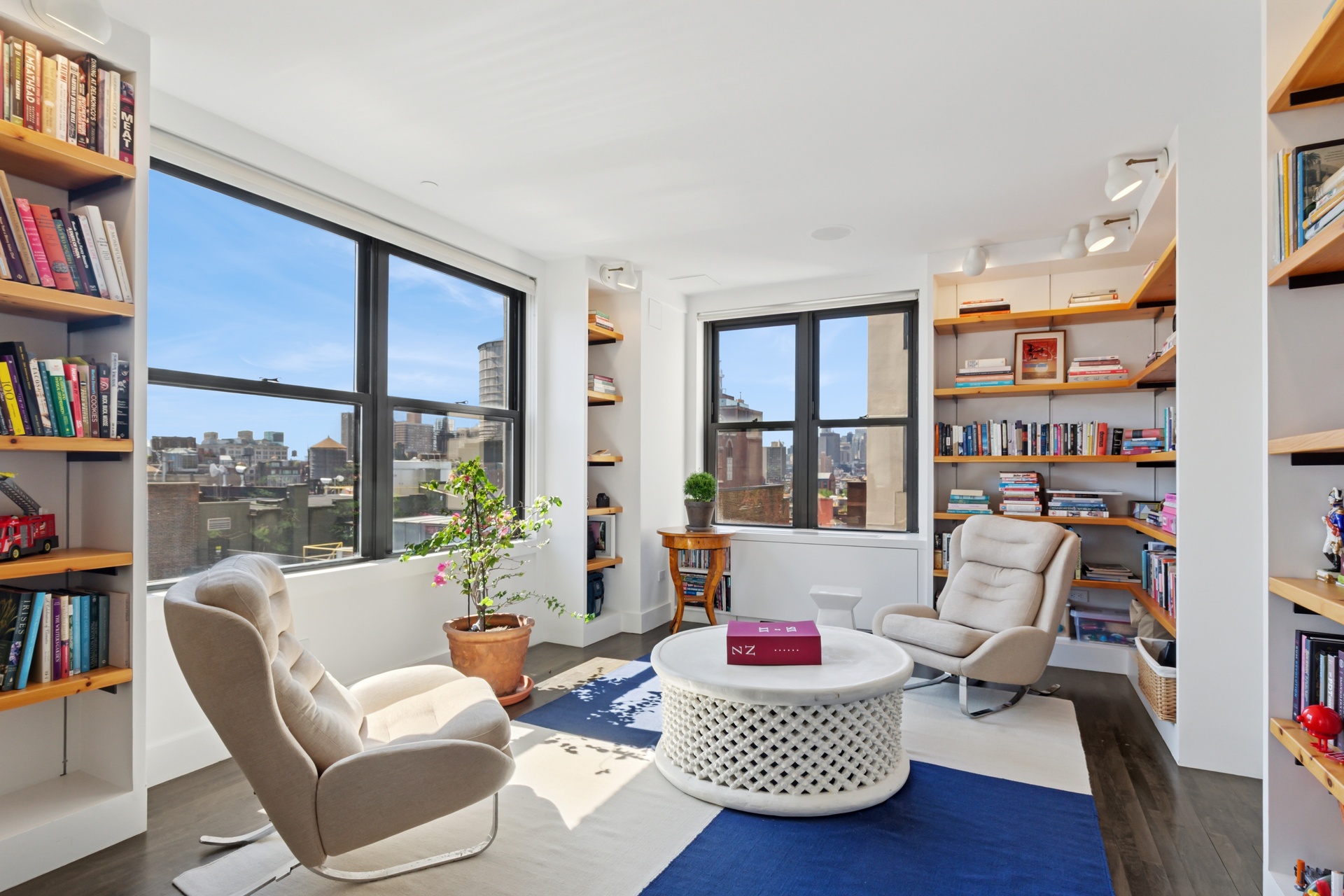65 West 13th Street, Unit PH1AB Manhattan, NY 10011 - Photo 7 of 27 a living room with furniture and a book shelf