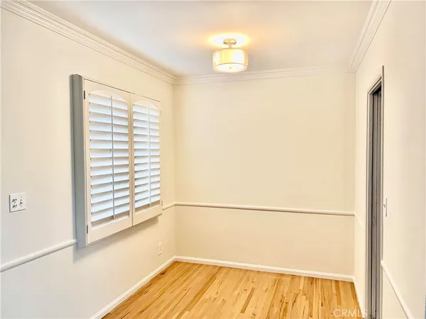 a view of a room with wooden floor and a window