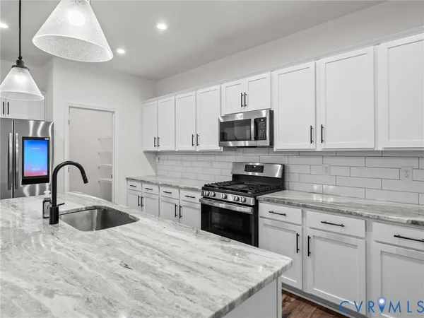 a kitchen with kitchen island a sink stainless steel appliances and cabinets