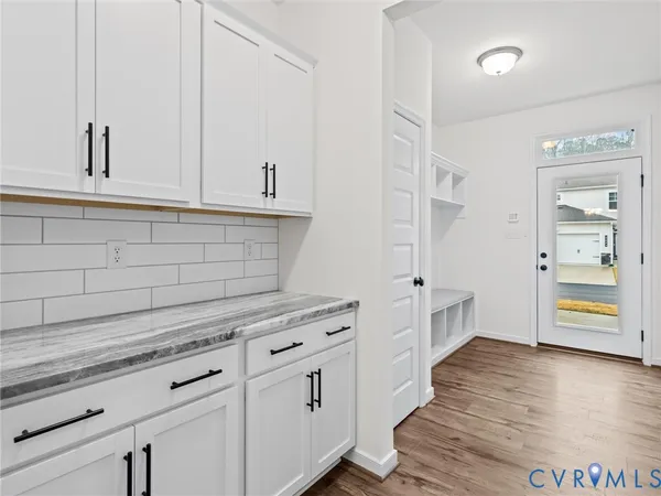a kitchen with stainless steel appliances white cabinets and a wooden floor