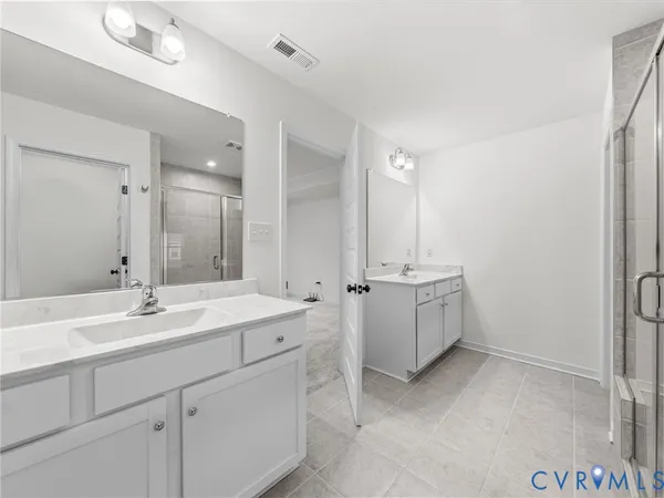 a bathroom with a double vanity sink mirror and bathtub