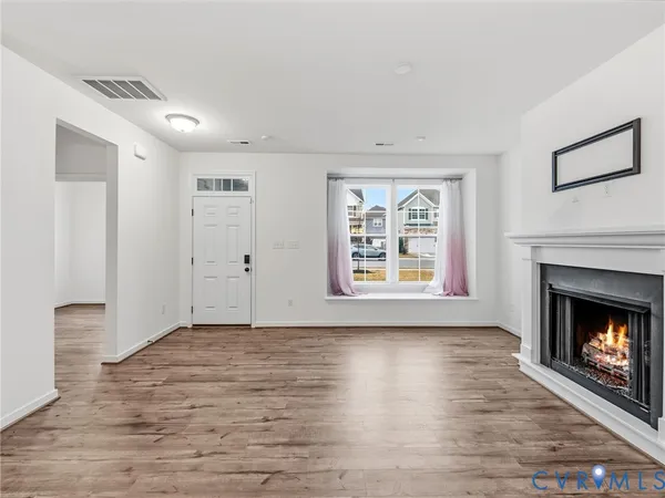 a view of an empty room with window and fire place
