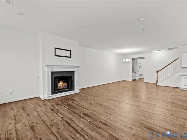 a view of empty room with wooden floor and fireplace