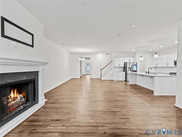 a view of an empty room and kitchen view