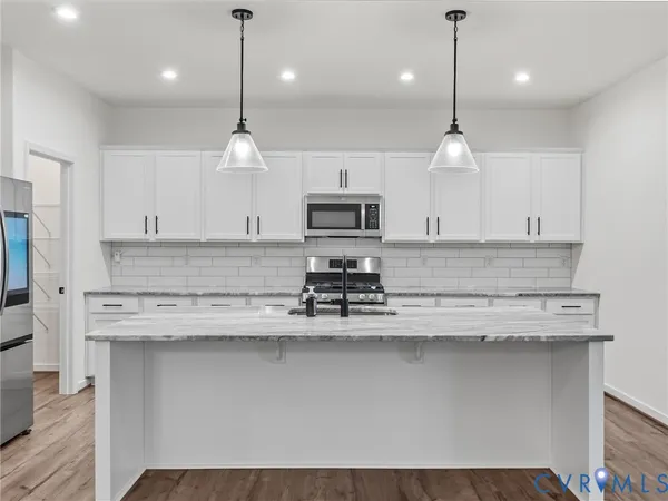 a kitchen with a sink a counter space appliances and cabinets