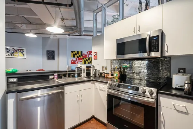 a kitchen with stainless steel appliances granite countertop a sink stove and microwave