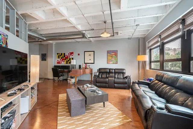 a living room with furniture a flat screen tv and a window