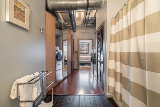 a view of a hallway with wooden floor and staircase