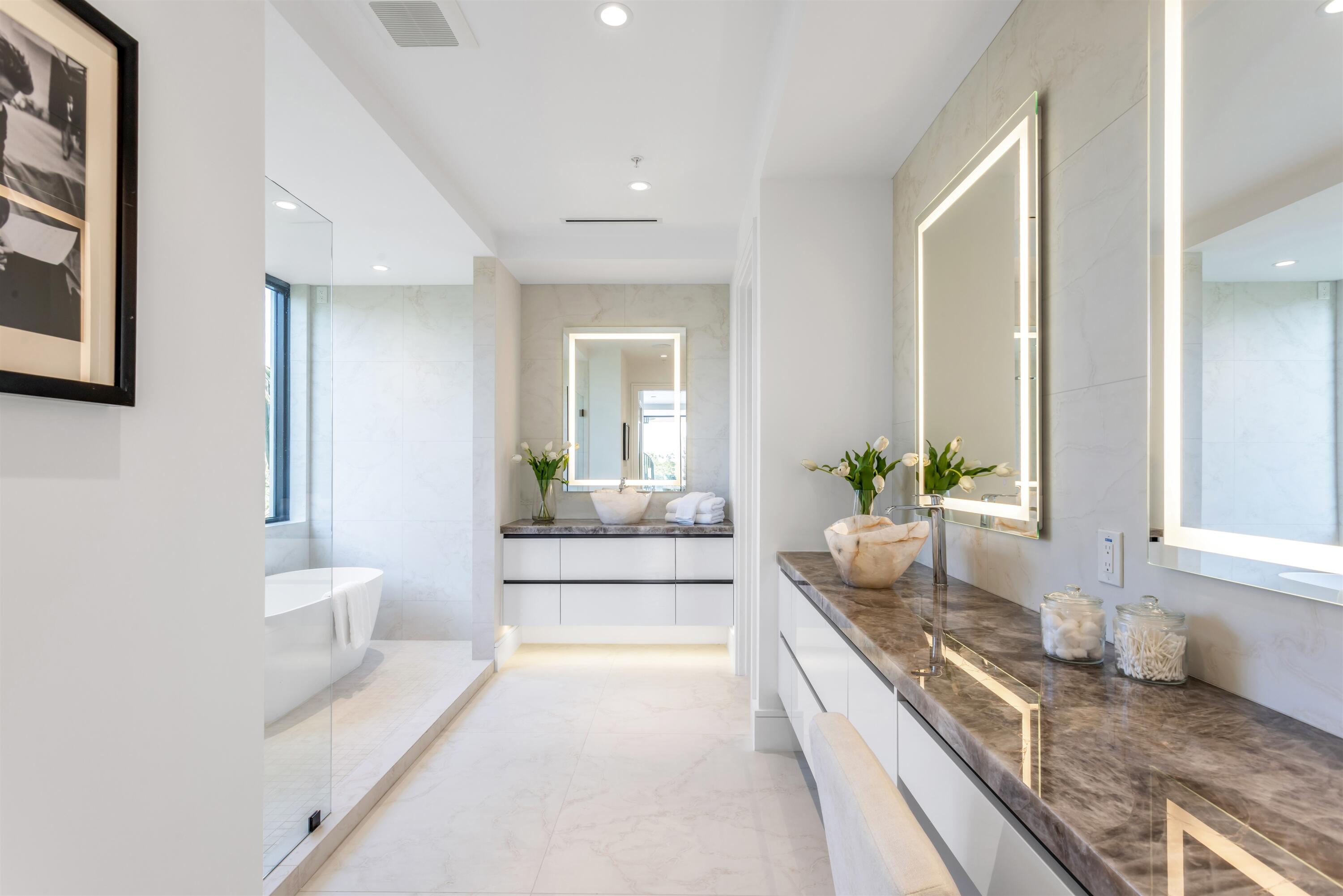 900 Lago Mar Lane, Unit PH Boca Raton, FL 33431 - Photo 23 of 58 a spacious bathroom with a granite countertop tub and a large mirror