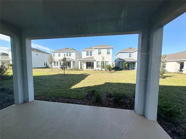 a view of a big house with a big yard and potted plants