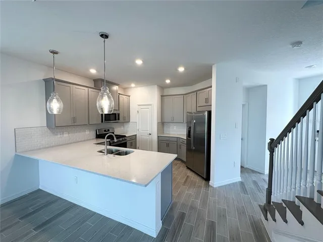 a kitchen with a sink a refrigerator and a stove