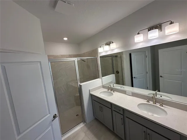a bathroom with double vanity sink and a mirror