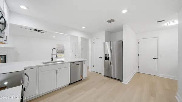a view of a kitchen with sink a refrigerator and window