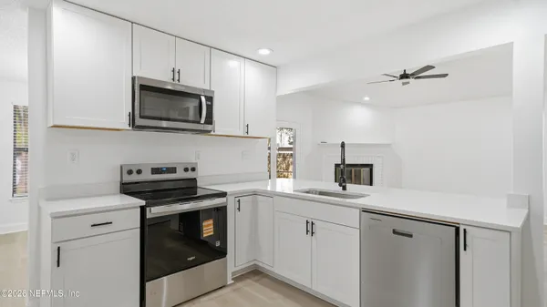 a kitchen with white cabinets stainless steel appliances and sink