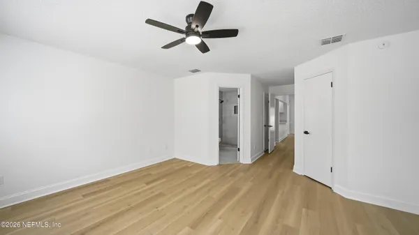 a view of empty room with wooden floor