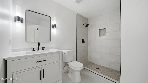 a bathroom with a sink a toilet and shower