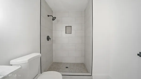 a bathroom with a granite countertop toilet a sink and shower