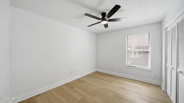 a view of a big room with wooden floor closet and windows