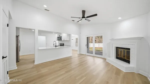 a view of a kitchen with a sink a fireplace and wooden floor