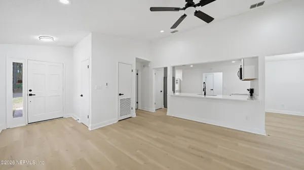 a view of a big room with wooden floor and windows