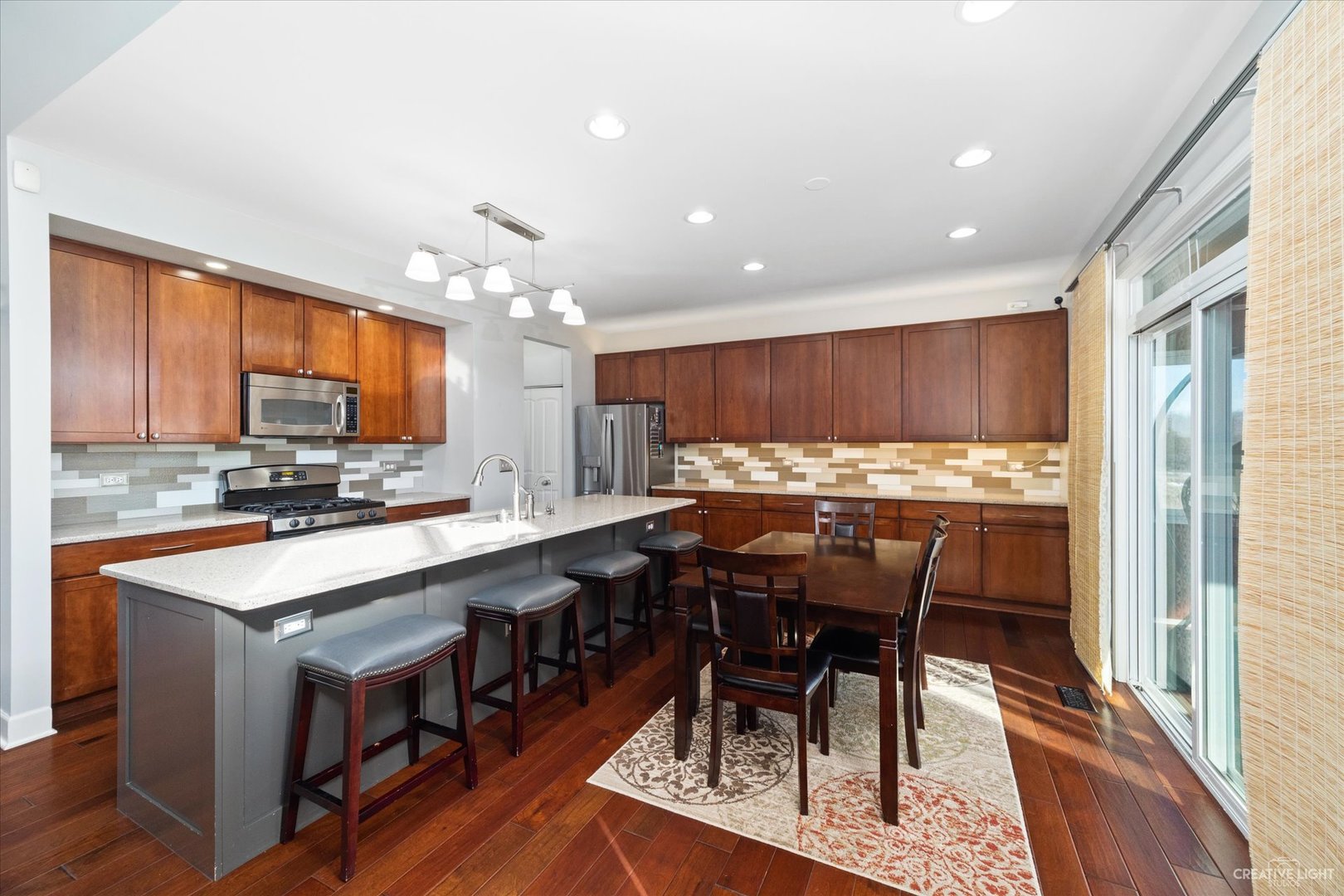 2933 Kelly Drive Elgin, IL 60124 - Photo 15 of 52 a kitchen with stainless steel appliances granite countertop table chairs sink refrigerator and cabinets