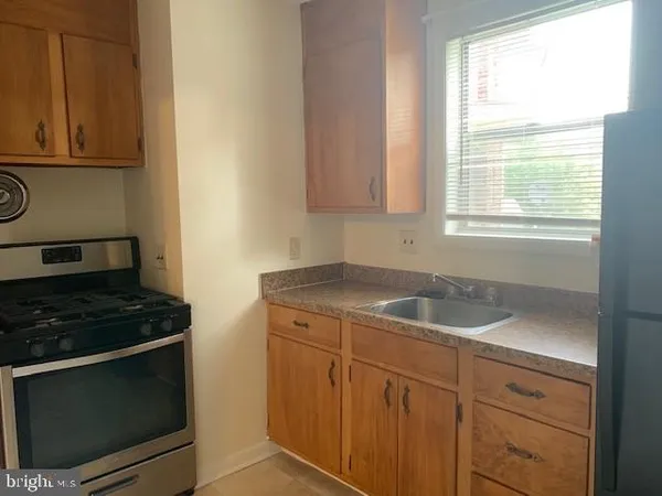a kitchen with granite countertop white cabinets and a stove