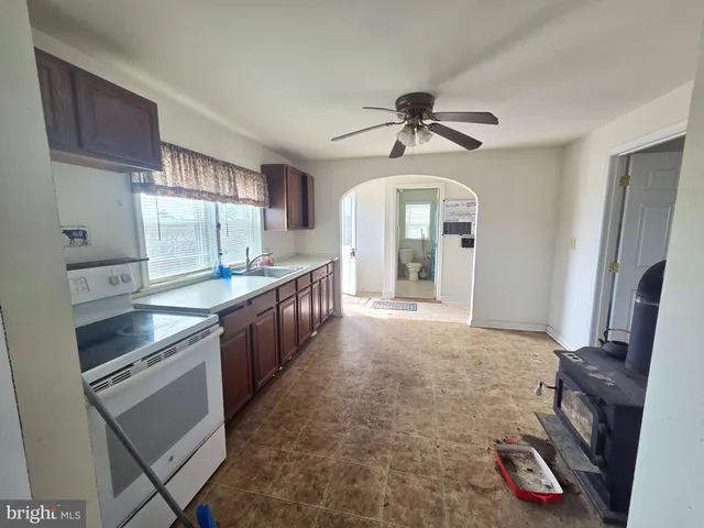 a room with wooden floor pool table and windows