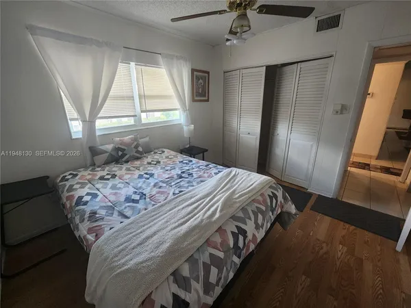 a bedroom with a bed a flat screen tv and a window