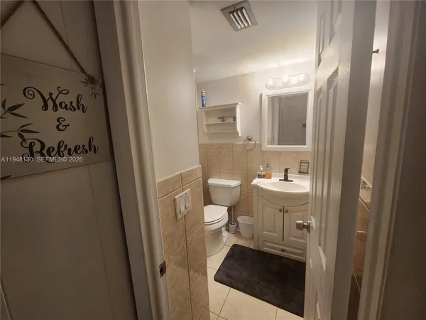 a bathroom with a sink and mirror with toilet