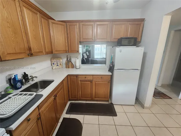 a kitchen with a refrigerator a stove a sink and cabinets