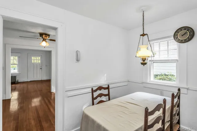 an empty room with wooden floor closet and windows