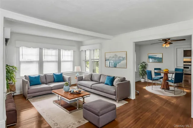 a white house with a small yard and large trees