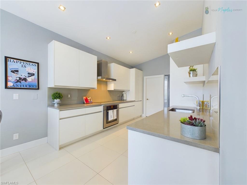 1952 Timarron Way Naples, FL 34109 - Photo 12 of 46 a kitchen with white cabinets and appliances