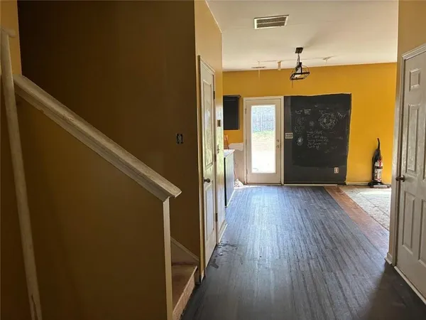 a view of a hallway with wooden floor and stairs