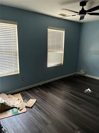a view of a room with wooden floor a ceiling fan and window