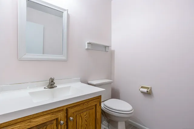 a bathroom with a sink a toilet and mirror