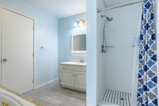 a bathroom with a sink a toilet a shower and a mirror