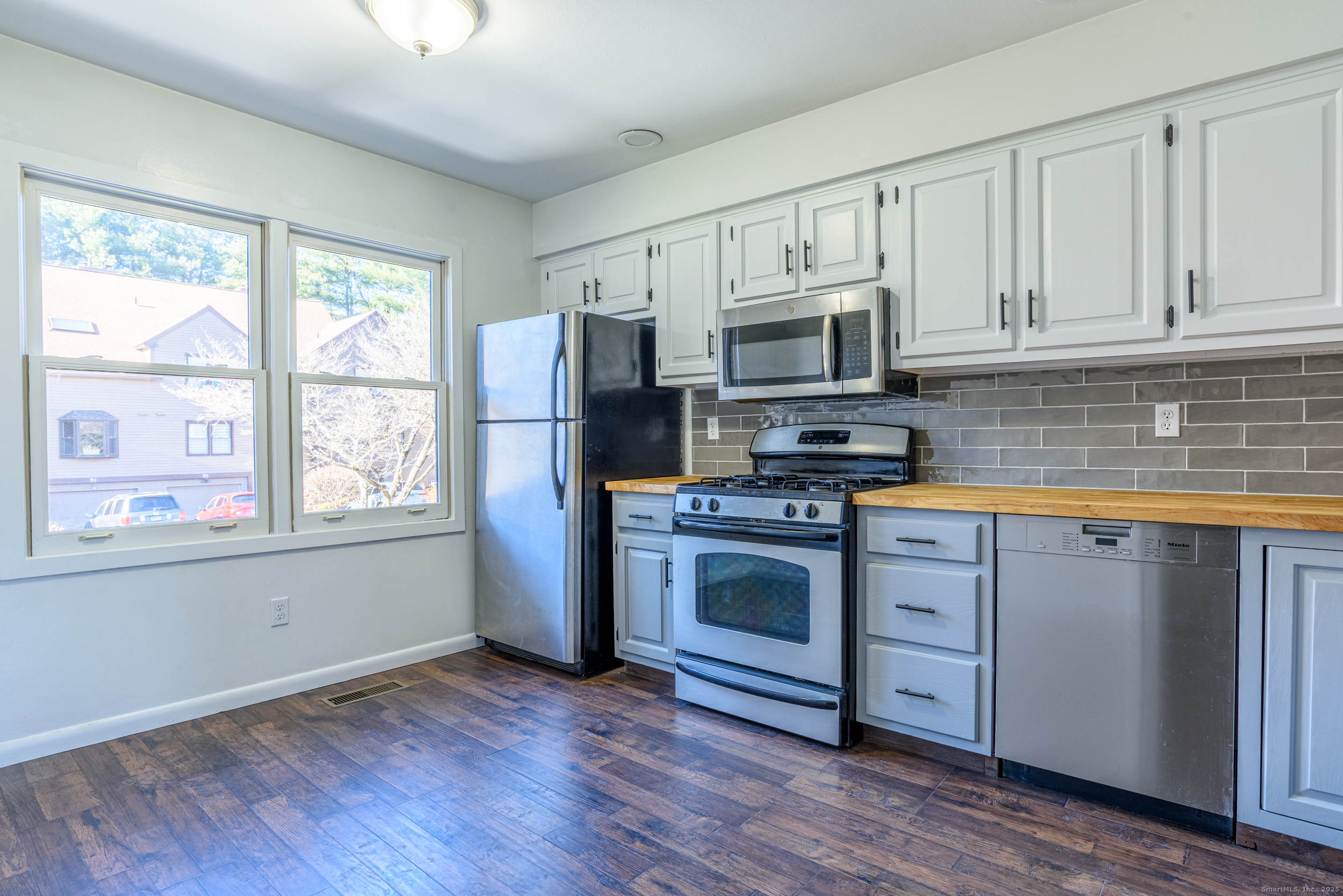 84 Stillmeadow Circle, Unit 84 Monroe, CT 06468 - Photo 4 of 20 a kitchen with granite countertop wooden floors stainless steel appliances a sink and a window