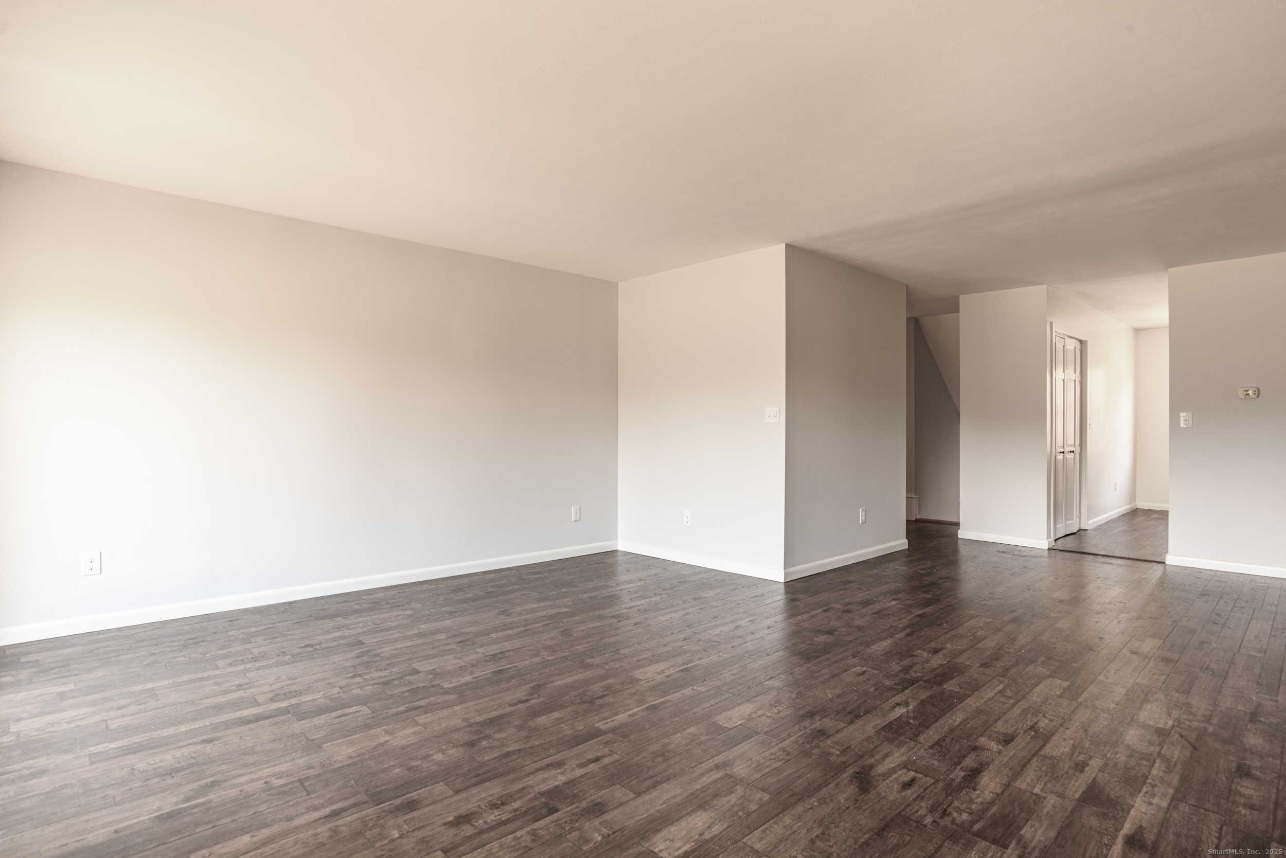 84 Stillmeadow Circle, Unit 84 Monroe, CT 06468 - Photo 7 of 20 a view of an empty room with wooden floor and a window