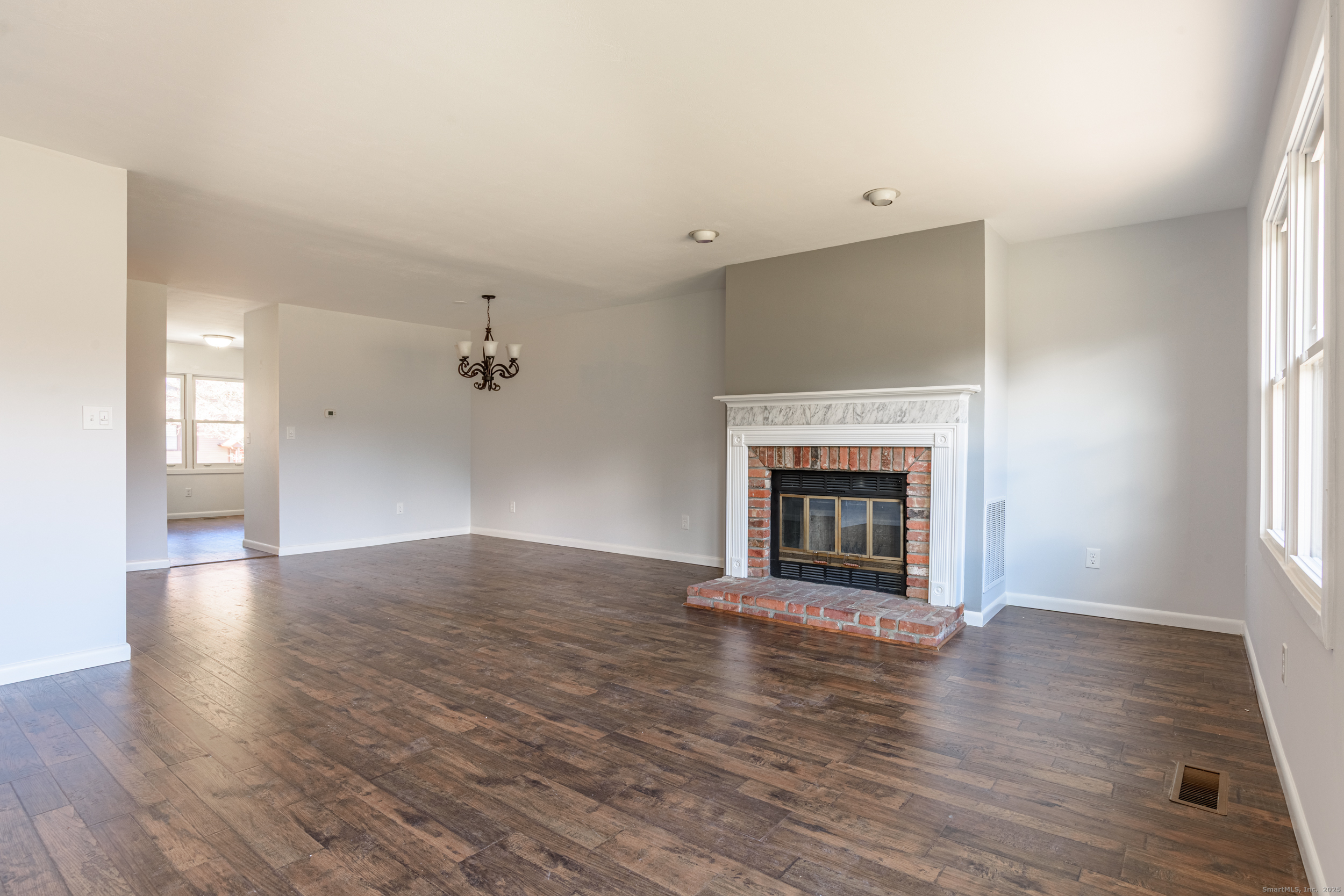 84 Stillmeadow Circle, Unit 84 Monroe, CT 06468 - Photo 8 of 20 an empty room with wooden floor fireplace and windows