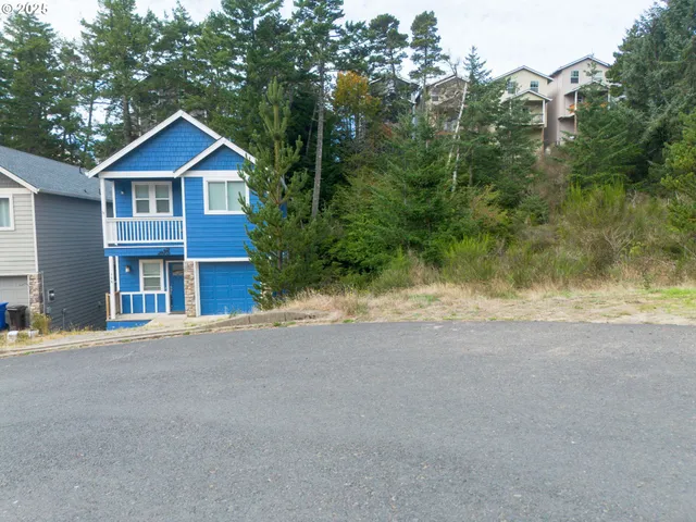 a view of a house with a yard and large trees