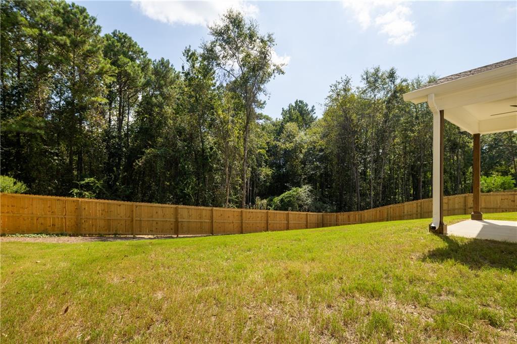 111 Lee Road Phenix City, AL 36867 - Photo 5 of 23 Spacious backyard with a wood privacy fence, concrete patio, and structural wood column