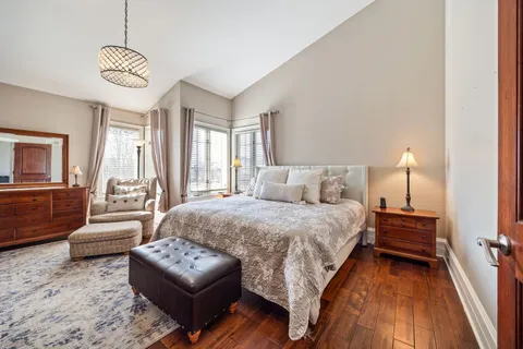 a bedroom with a bed a mirror on dresser and a window